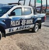 Patrulla de la Policía Municipal de El Arenal estacionada sobre un camino de tierra al lado de un tramo carretero