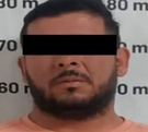 un hombre  detenido con los ojos cubiertos