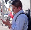 un hombre ve su teléfono celular mientras está en la calle