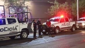 Patrullas y oficiales de la Policía Municipal de Tlaquepaque al lado de un hombre con la cara censurada y playera roja