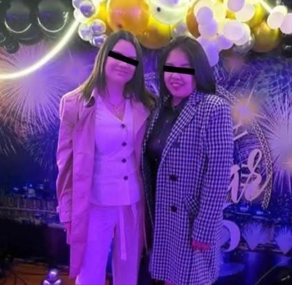 Dos mujeres posando para una fotografía en un salón con luces neón.