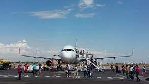 Avión en pista de aterrizaje con varias personas descendiendo.