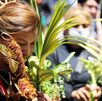 una mujer sostiene una palma durante el domingo de ramos