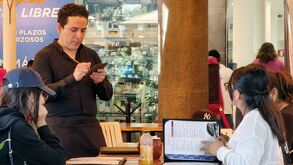 un mesero atiende a dos personas en un restaurante en puebla