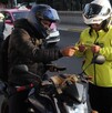Un motociclista mostrando su licencia de conducir a un policía de transito durante un operativo en la CdMx