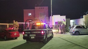 Se observa una ambulancia estacionada, es de noche y hay otros vehículos.