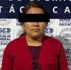 Mujer vestida de rojo presentada ante autoridades de Oaxaca luego de ser detenida.