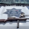 Pistola tipo revolver y un arma larga calibre .22 con municiones colocados sobre el cofre de una patrulla de la Policía Municipal de Guadalajara