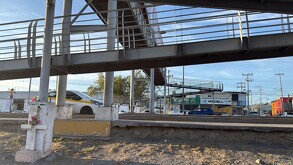 Se observa un puente peatonal y varios carros circulando.