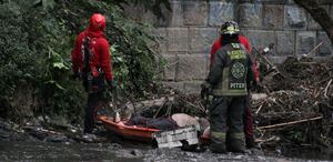 Personas con trajes especiales haciendo labores de rescate en un río.