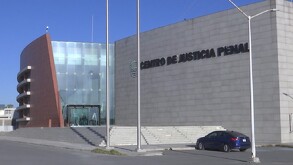 Se observa un edificio color gris con letras que dicen Centro de Justicia Penal.