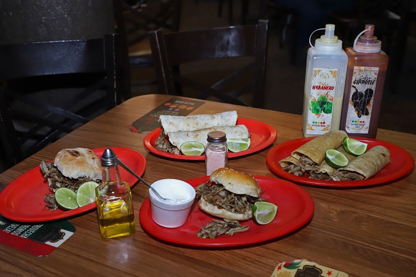 Cemitas y tacos de carne árabe servidos sobre platos rojos.