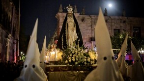 Miles de fieles marchan encapuchados y vestidos de negro junto a la Virgen de la Soledad en la Procesión del Silencio en Guadalajara
