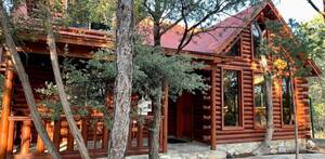 Cabaña de madera ubicada en una zona boscosa de Arteaga, representando el tipo de hospedaje turístico que busca ser regulado por autoridades.