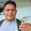 Persona sonríe y enseña su licencia de conducir del estado de Puebla.