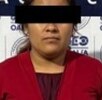 Mujer vestida de rojo presentada ante autoridades de Oaxaca luego de ser detenida.
