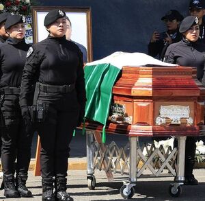 Mujeres policías formadas junto a un féretro con el cuerpo de un compañero fallecido.