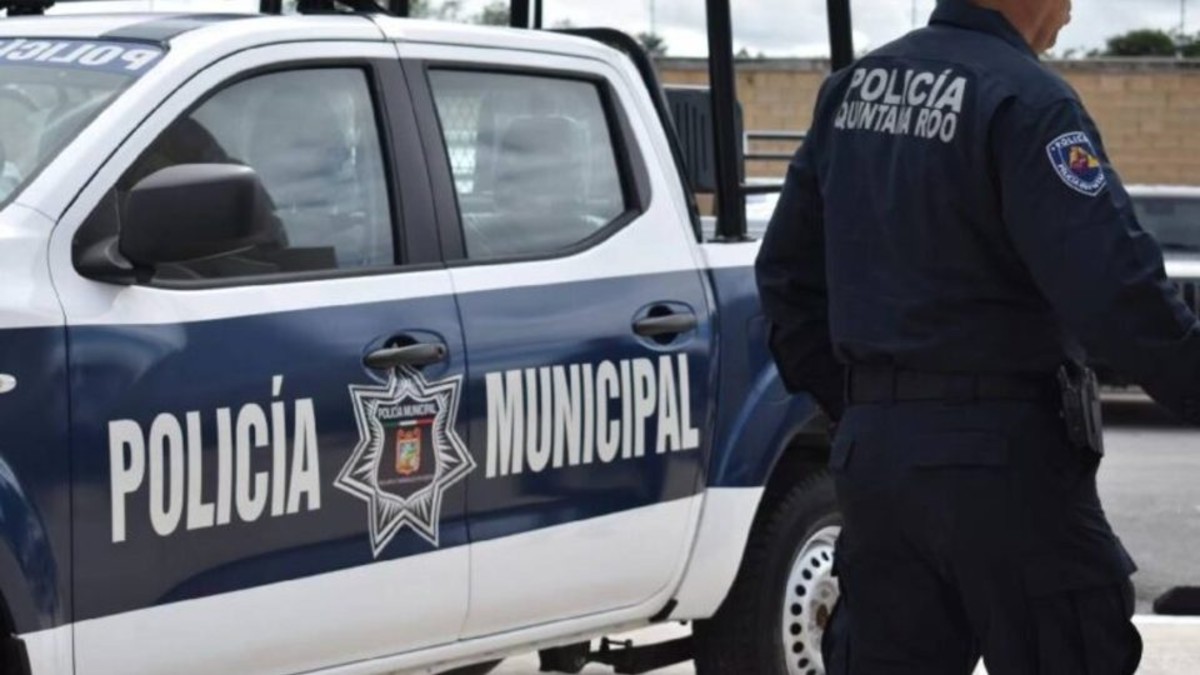 Policía de Quintana Roo al lado de una patrulla de la Policía Municipal de Cancún