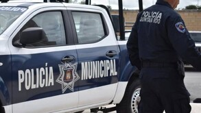 Policía de Quintana Roo al lado de una patrulla de la Policía Municipal de Cancún