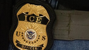 Un agente federal lleva una placa del Servicio de Inmigración y Control de Aduanas en Nueva York