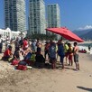 Paramédicos, elementos de Protección Civil de Puerto Vallarta y turistas rodeando a una persona en medio de la playa