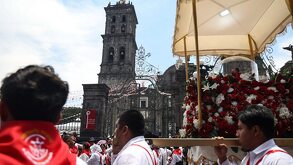 personas cargan una imagen religiosa en la procesión de viernes santo frente a la catedral de puebla