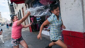Niñas se avientan agua en el centro histórico de la Ciudad de México