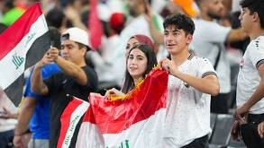 Aficionados del equipo de futbol de Irak sosteniendo la bandera de Irak