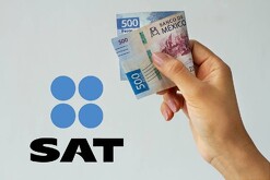Una mano sosteniendo un billete doblado de 500 pesos mexicanos con un logo del SAT a un lado