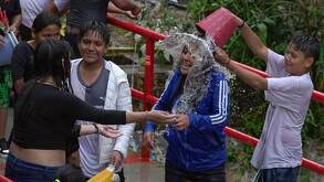 Personas mojándose el Sábado de Gloria