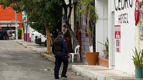 Policía caminando cerca de la entrada de un hotel en Cancún tras un transfeminicidio.