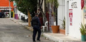 Policía caminando cerca de la entrada de un hotel en Cancún tras un transfeminicidio.
