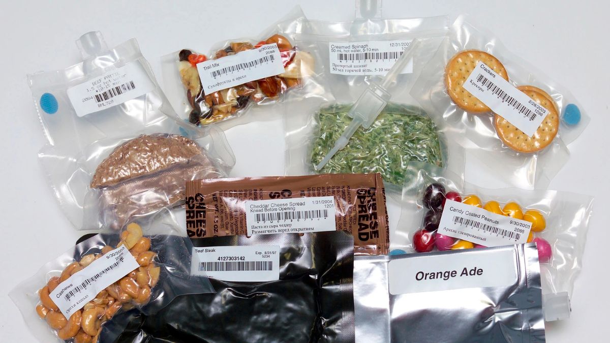 Diversos alimentos espaciales en empaques sellados, diseñados para conservarse sin refrigeración y ser consumidos en condiciones de microgravedad.
