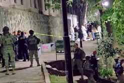 Militares del Ejército y Oficiales de la Policía de Michoacán en un parque con peritos forenses en un área acordonada