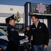 Javier Díaz saluda a una oficial de policía frente a la Academia de Policía de Saltillo, mientras una patrulla municipal y otros elementos se observan en el fon