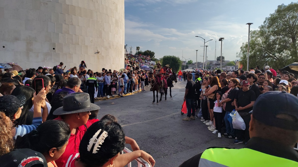 Una gran cantidad de personas se congrega en las calles de Saltillo para presenciar el viacrucis del Ojo de Agua, con elementos de seguridad y asistentes.