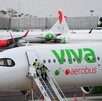 Aviones de Viva Aerobus en el aeropuerto de Ciudad de México con trabajadores descendiendo por una escalera