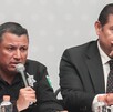Dos hombres sentados frente a una mesa para una rueda de prensa.