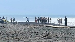 Multitud de personas y policías de Colima reunidos a la orilla del mar en la playa de Boca de Pascuales