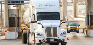 Tráiler avanzando en una caseta de cobro en una carretera.