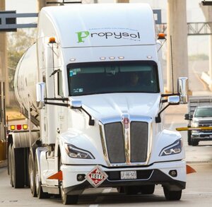 Tráiler avanzando en una caseta de cobro en una carretera.