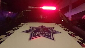 Vista del cofre de una patrulla con el escudo de la Policía Municipal de Guadalajara con la luz roja de la sirena encendida