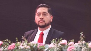 Pedro Valencia Cerecero, secretario de Ocampo en Michoacán, con un arreglo de flores enfrente