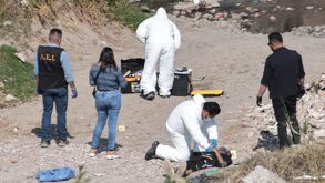 Personal forense laborando en una zona de tierra para atender el hallazgo de hombres sin vida en Puebla.