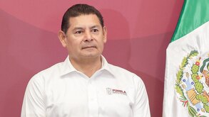 El gobernador de Puebla, Alejandro Armenta, junto a una bandera de México.