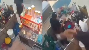 Mujer aventando líquido a compañera con ropa negra