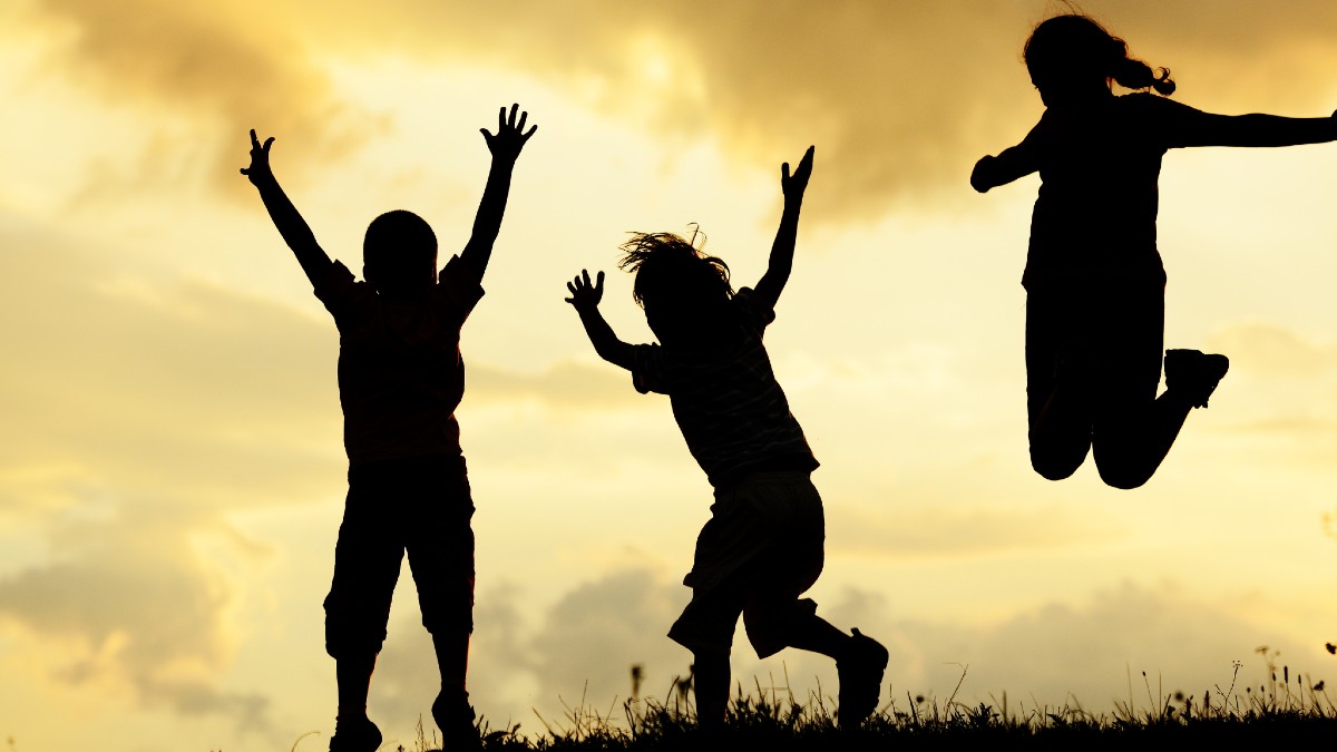niños brincando a contraluz divirtiéndose en los puentes de mayo