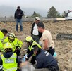 Se observa a varias personas sobre una terracería; hay paramédicos de Cruz Roja.