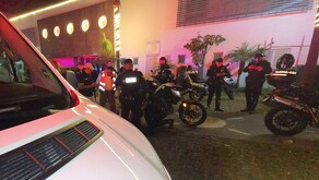 Paramédicos y policías de Guadalajara atendiendo a un oficial de Zapopan con dos motopatrullas en el sitio