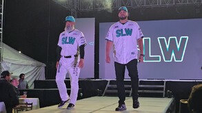 Se observa a dos hombres modelando unos uniformes color blanco con verde y letras que dicen SLW.